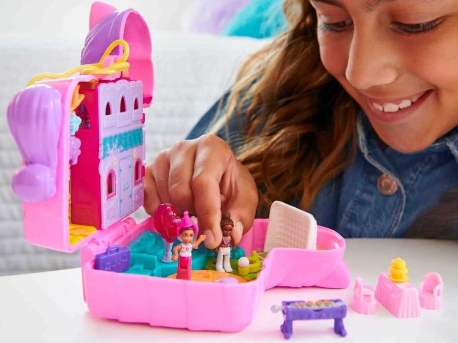 A girl playing with tiny plastic dolls