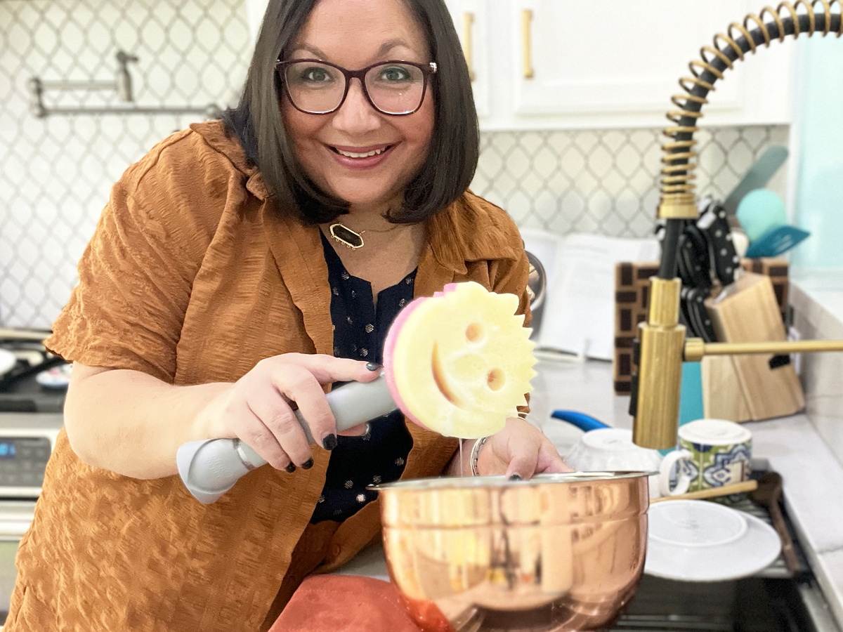 woman holding up scrub mommy on a dish wand