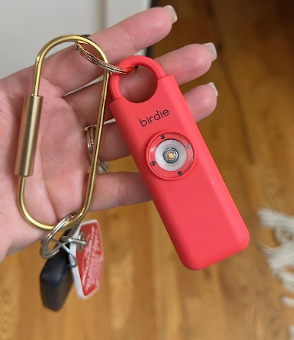 hand holding red personal birdie alarm on keychain