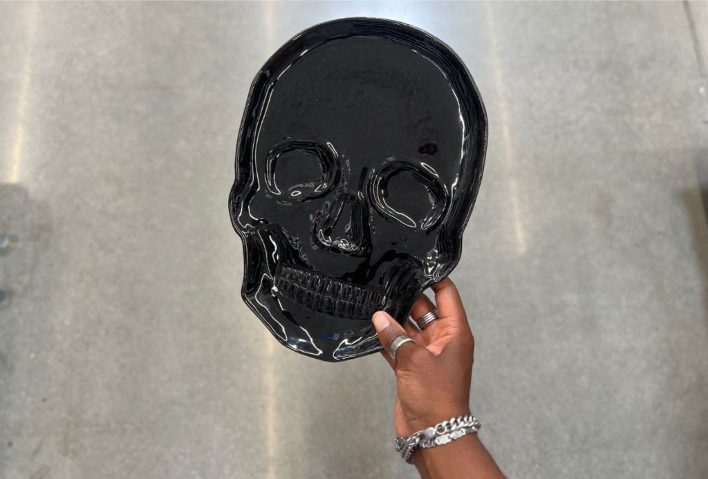 a womans hand holding a skull serving tray from walmart