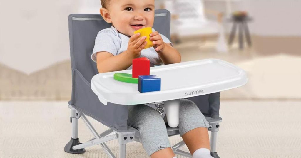 Baby sitting in a Summer Infant Pop N Sit playing with blocks