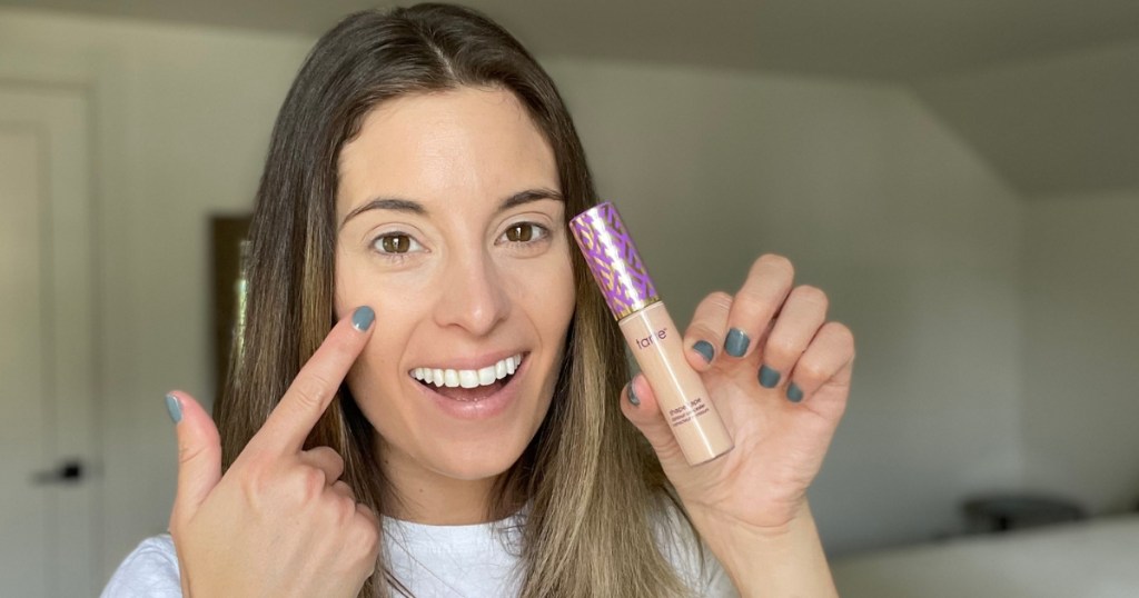 woman holding tarte shape tape concealer