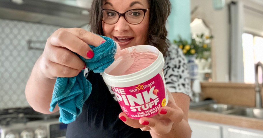 woman holding the pink stuff cleaning paste with rag