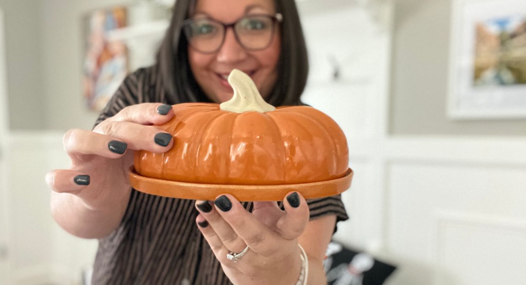 Woman holding pumpkin shaped butter dish