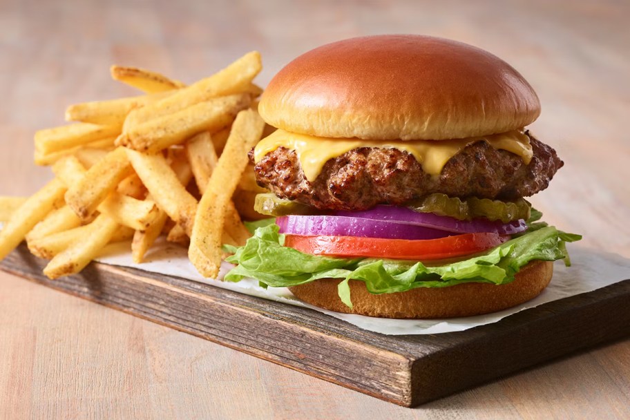 cheeseburger with fries on cutting board