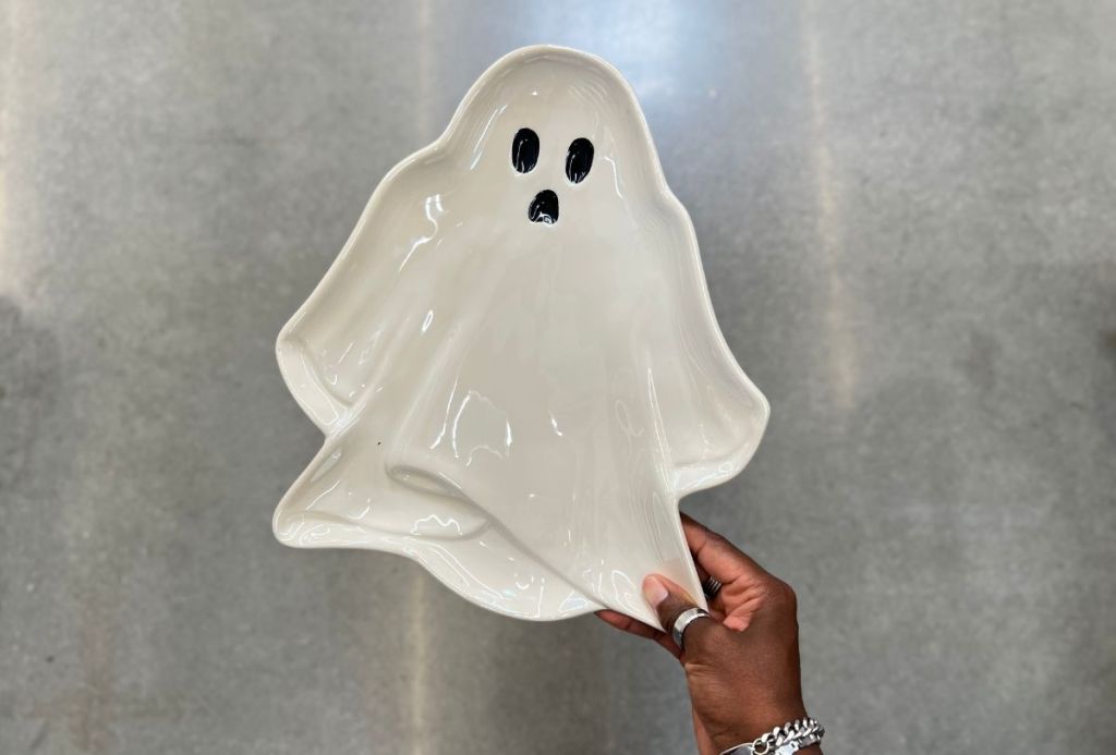 a womans hand holding a ghost serving tray from walmart