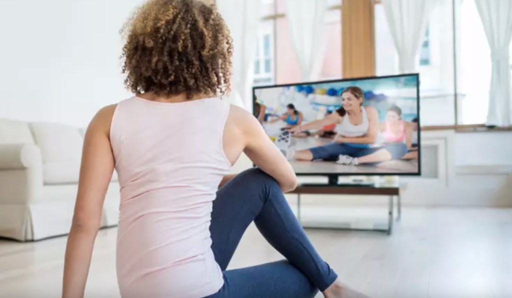 woman looking at screen doing yoga