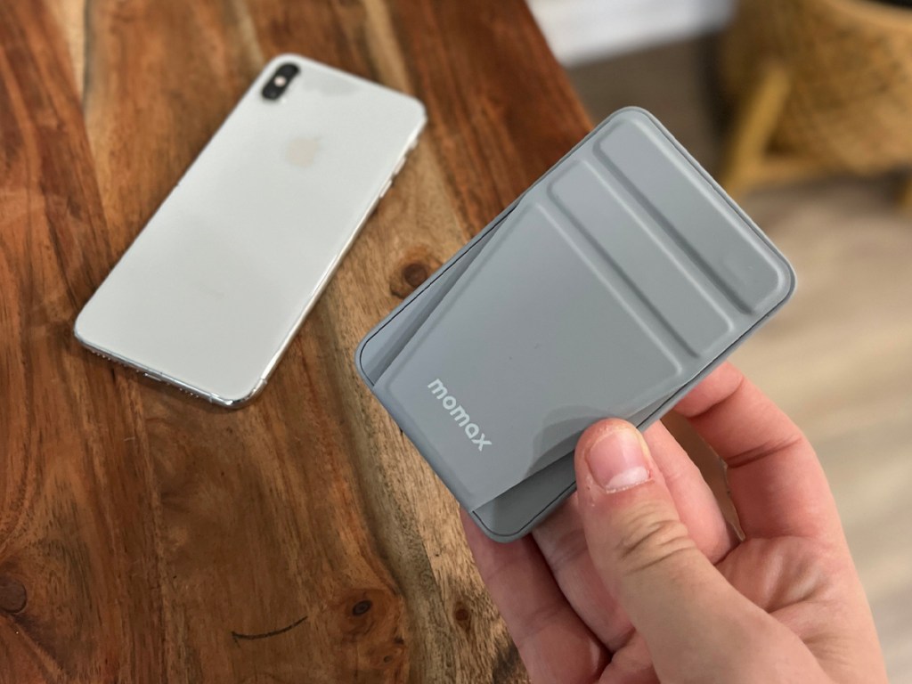 hand holding gray charger next to white iphone