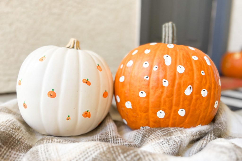 two fingerprint painted pumpkins side by side