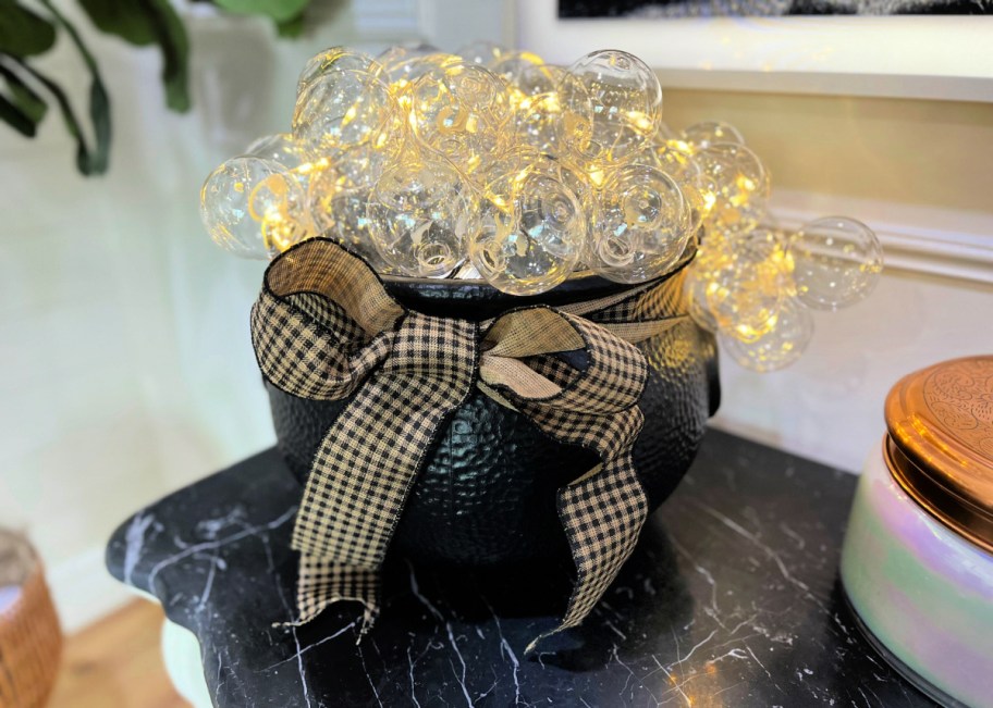 Witches cauldron with fairy lights displayed on a Halloween table