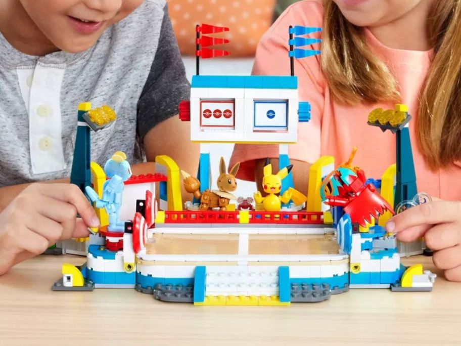 kids playing with a Pokemon Training Center sets with various Pokemon figures