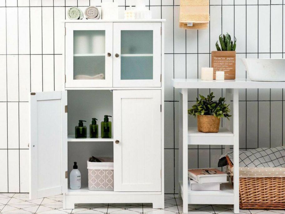 a white linen. cabinet with doors open showing storage space and contents