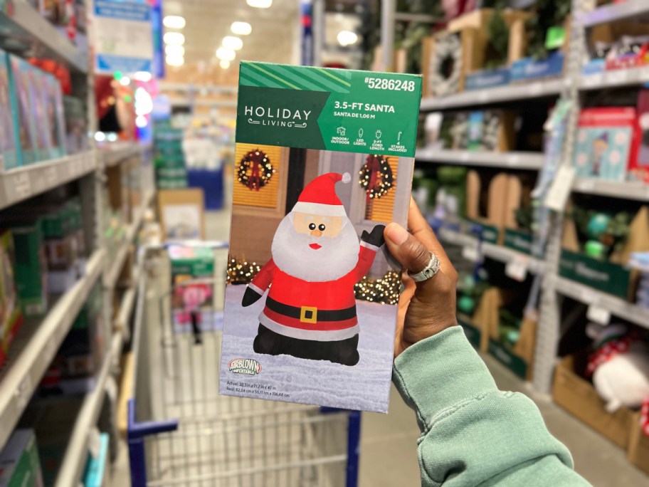 person holding santa inflatable inside lowes