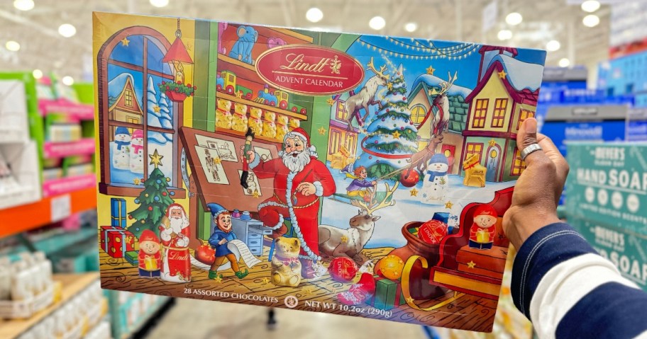 hand holding a colorful Lindt Chocolate Advent Calendar box with Santa and the North Pole village on it