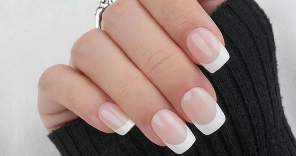 Hand wearing french tip press on nails