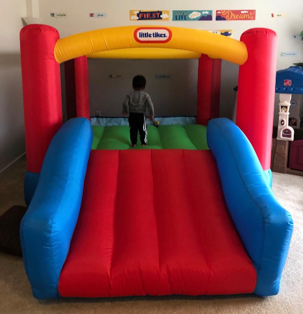 toddler bouncing on little tikes yellow red and blue bounce house