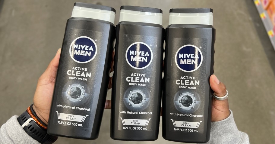 hand holding 3 black bottles of Nivea Men Body Wash