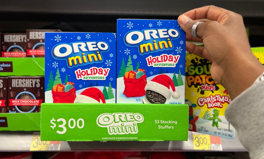 Hand grabbing an Oreo Mini Holiday Adventures Storybook Stocking Stuffer from Walmart