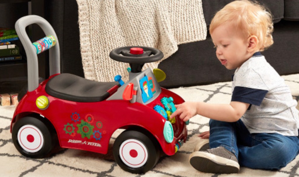 toddler baby playing with radio flyer ride on car