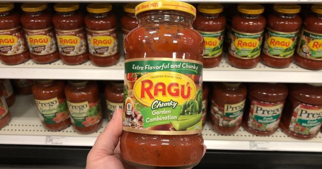 Hand holding a jar of Ragu Garden onlinebination pasta sauce