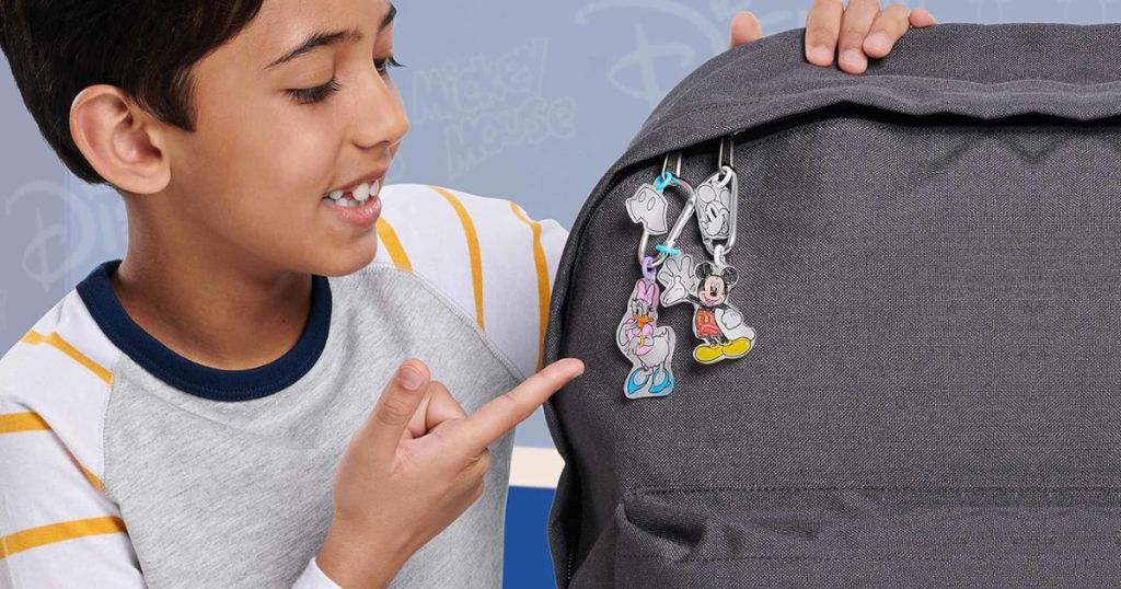 Boy pointing to Shrinky Dink keychains hanging on a backpack