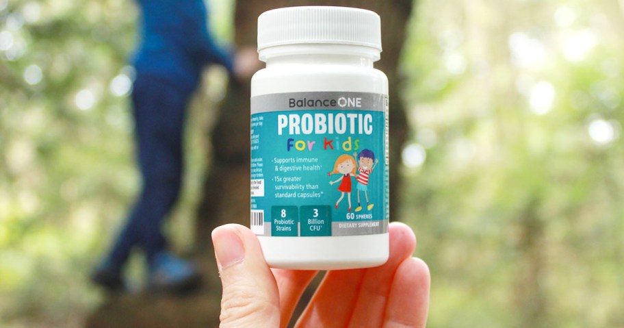 hand holding balance on probiotic bottle