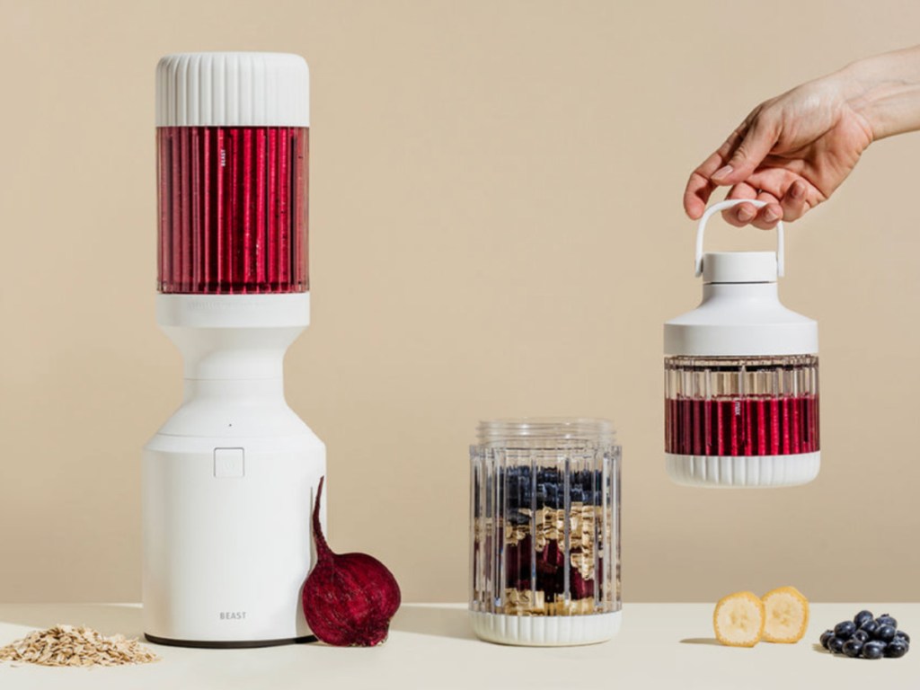  deluxe blender with cup, fruit and hand holding