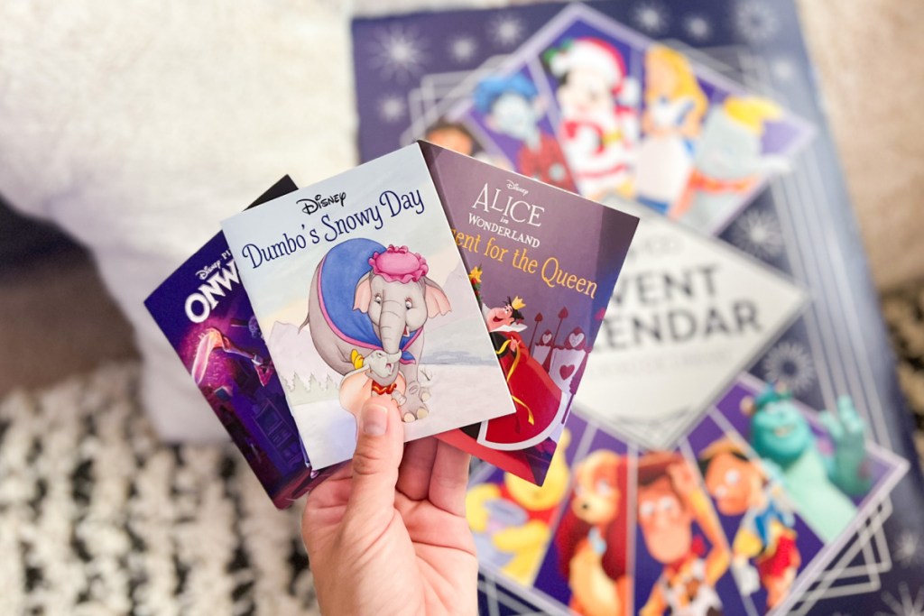 hand holding mini books above advent calendar