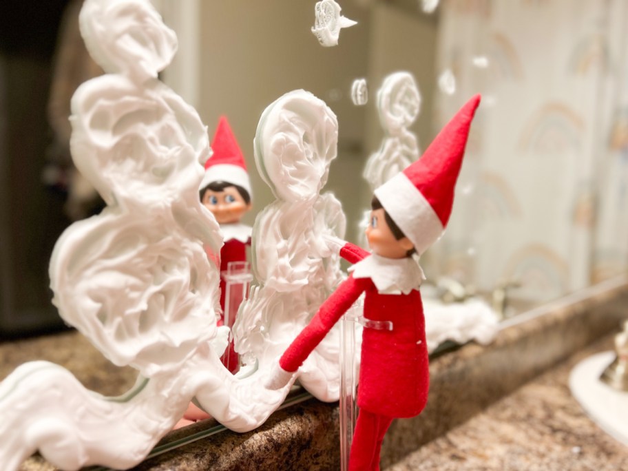 elf making shaving cream snowmen on mirror