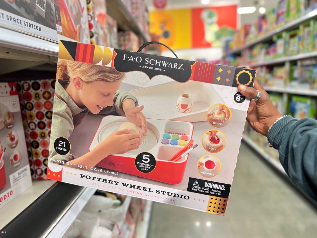 holding a toy pottery wheel in its package