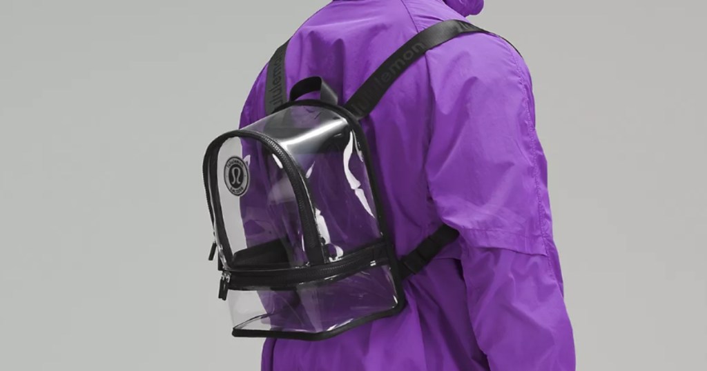 Clear lululemon backpack on the back of a person wearing a purple jacket.