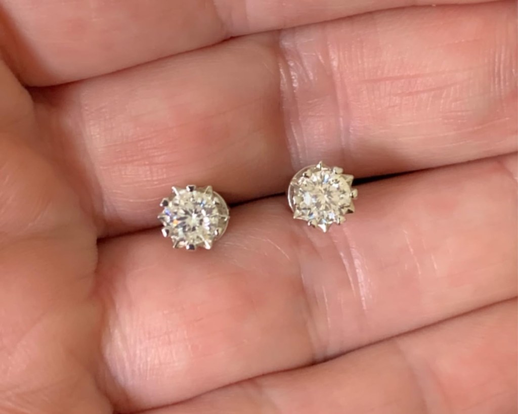 moissanite studs in between fingers