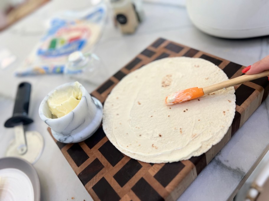 spreading butter on a tortilla