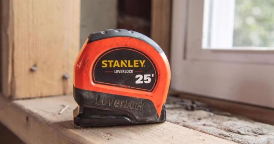 orange and red Stanley Tape Measure on a windowsill