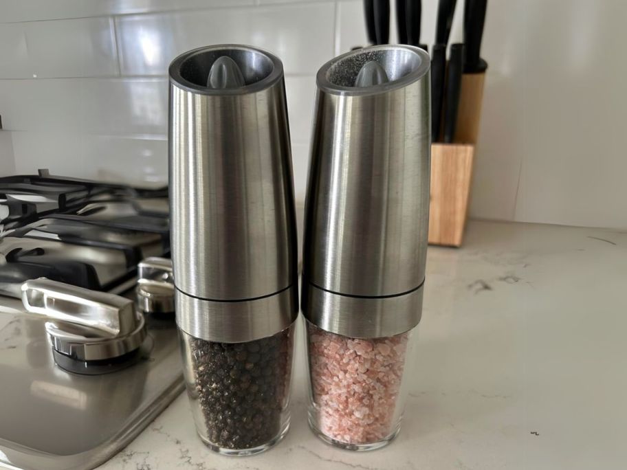 Electric Salt & Pepper Mill Set on kitchen counter next to stove with knife block in background