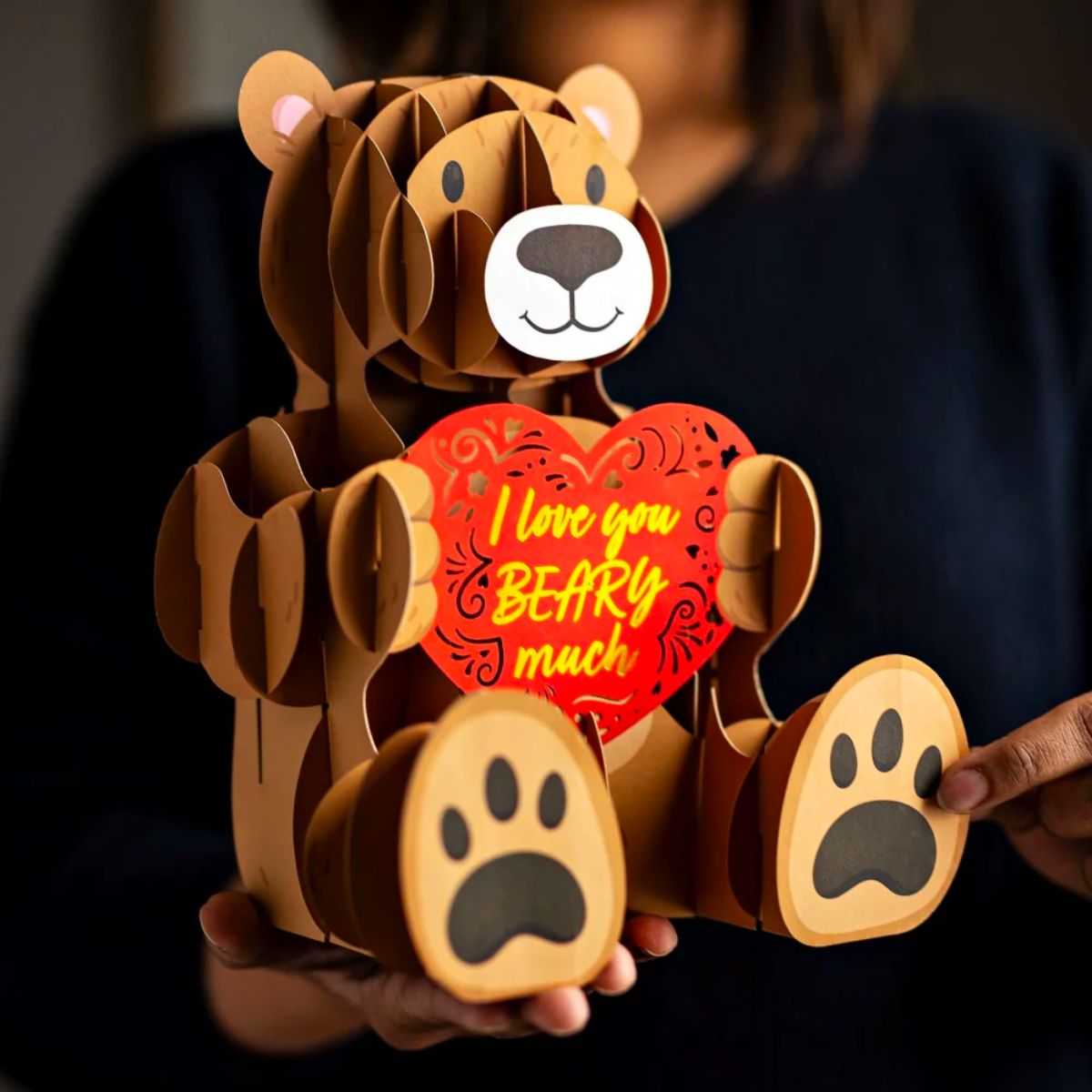 a woman holding a Giant Love Bear pop up card