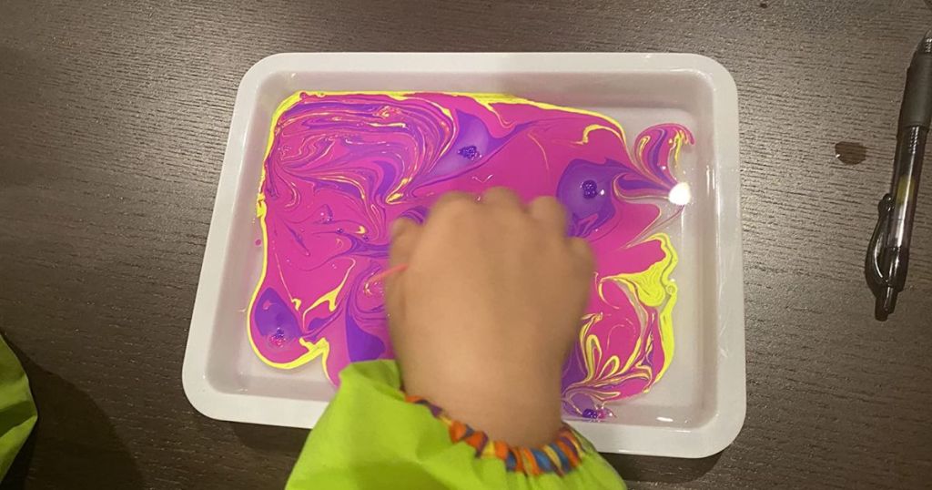 kid's hand in a paint tray from Dan&Darci Marbling Paint Art Kit for Kids