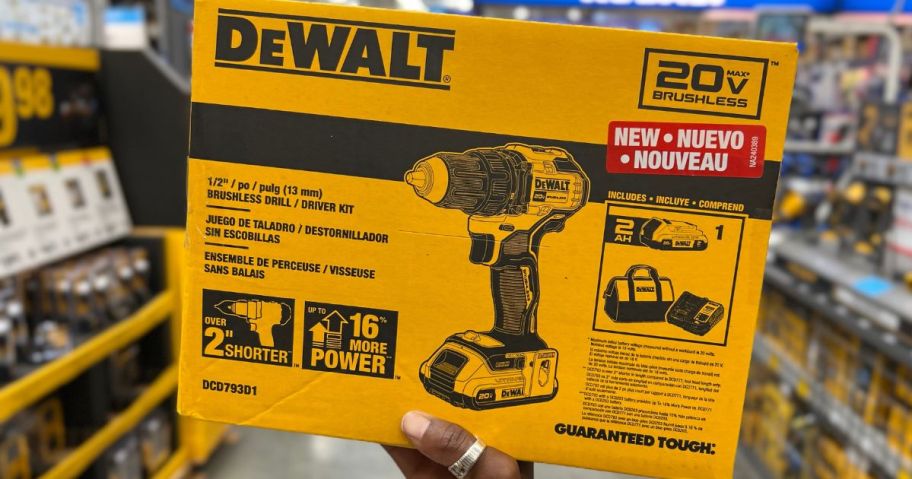 hand holding a yellow box with a DEWALT power drill in it