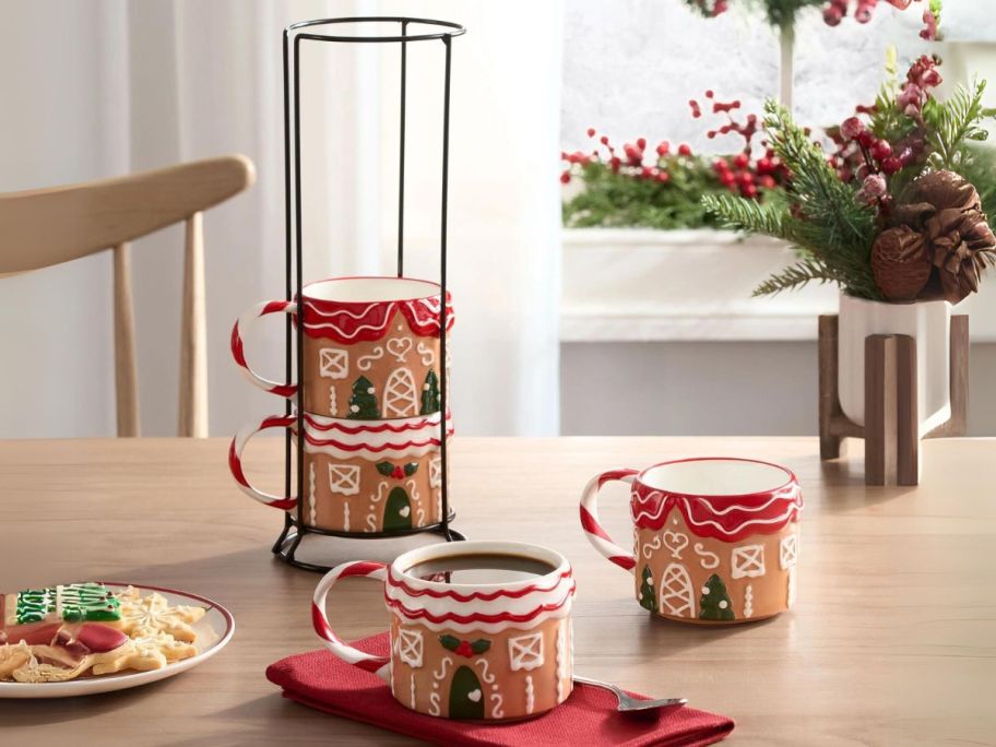 Holiday Time 12oz Gingerbread House Glazed Stoneware Ceramic Stacking Mug Set w/ Metal Rack on table