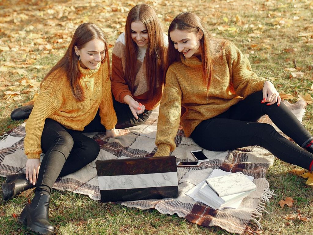 3 girls watching a laptop and laughing