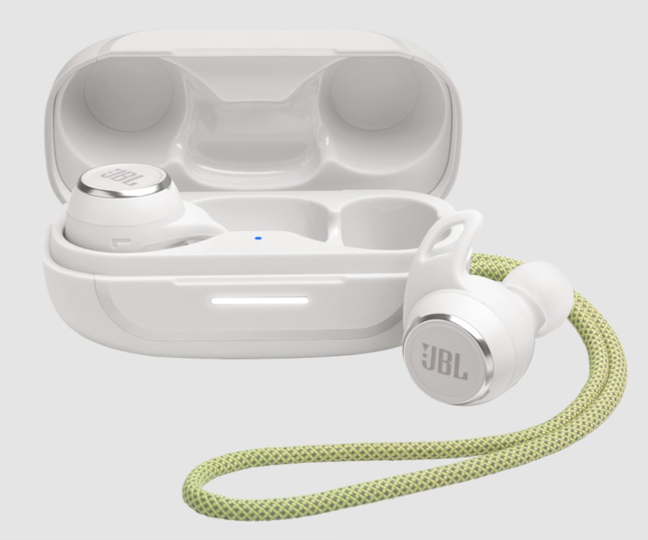 white and green earbuds next to charging case