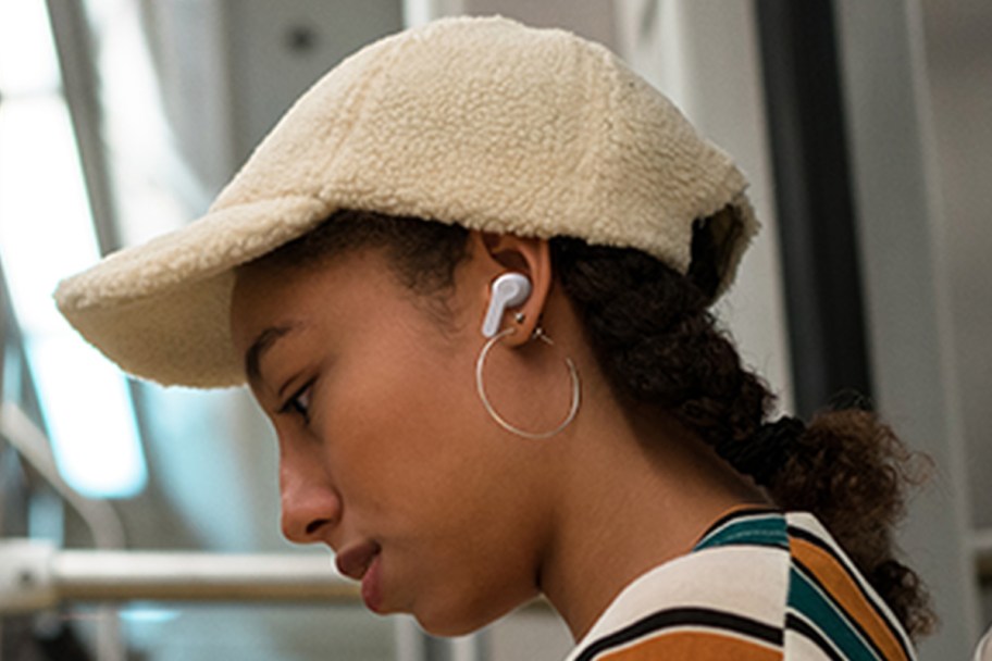 woman in hat with white earbuds