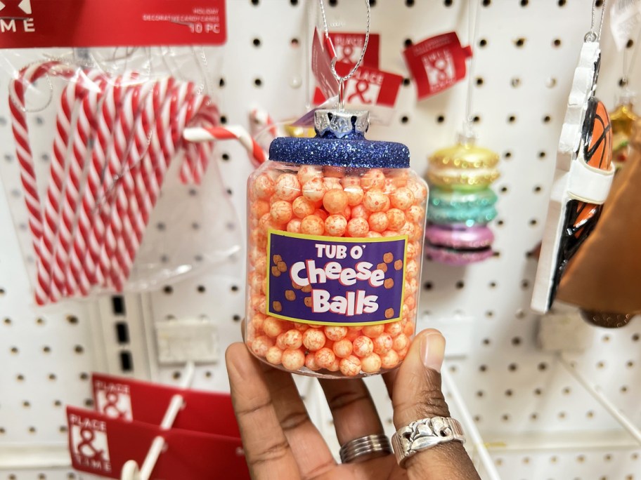 hand holding a cheese balls christmas ornament in store