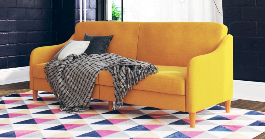 yellow futon with throw pillows and blanket