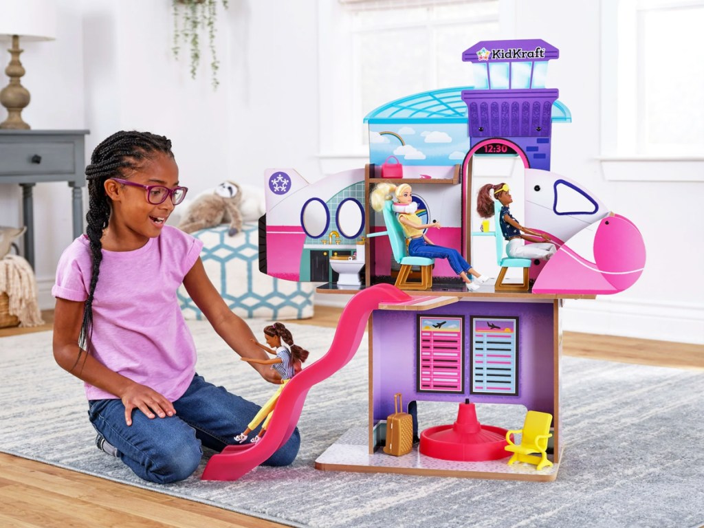 girl playing with airplane themed dollhouse set