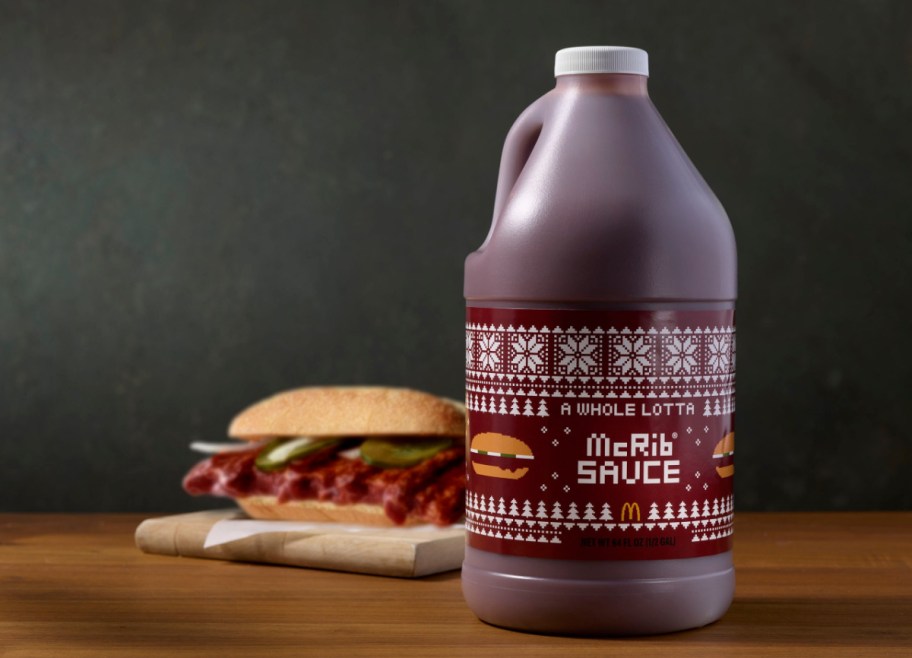 The A Whole Lotta McRib Sauce jug next to a McDonald's McRib Sandwich