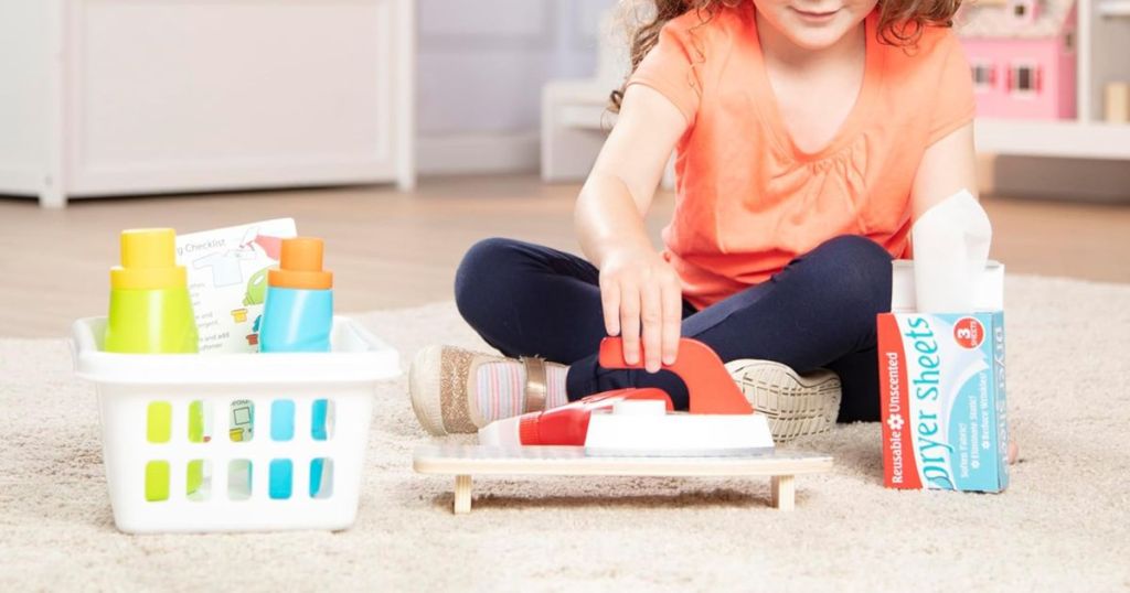 A child playing with a Melissa & Doug Laundry Playset