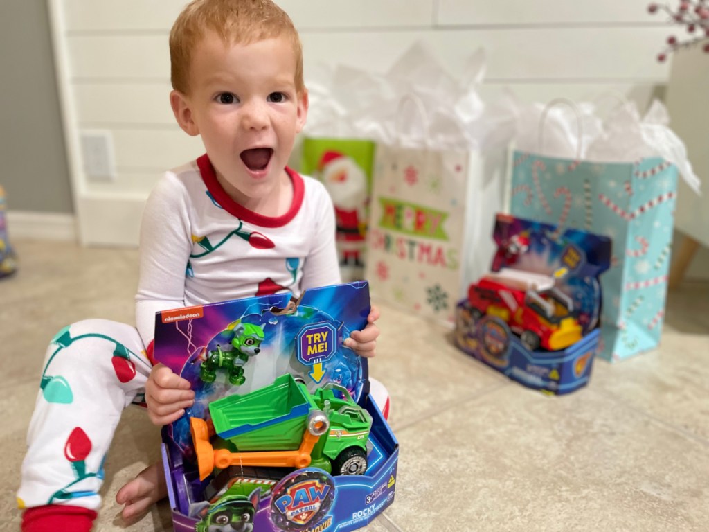 Boy excitedly opening a Paw Patrol The Movie Recycler Truck Toy from Walmart which cost under $25