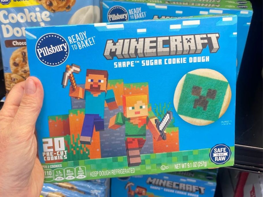 Hand holding a box of Pillsbury Ready to Bake Minecraft Pre-Cut Sugar Cookie Dough 