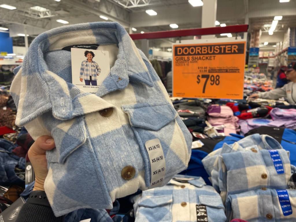 person holding up $7.98 Shacket inside sams club